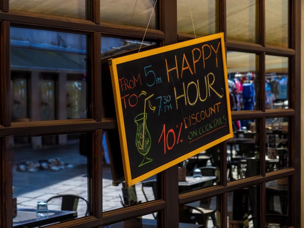a signboard of happy hour timing at a restaurant.